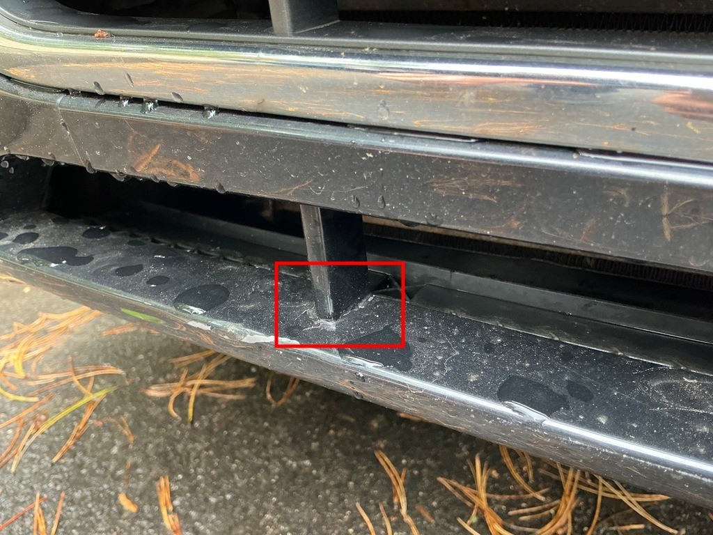 Detailaufnahme Frontstoßfänger unten, Riss/Bruch im Kunststoff rot markiert, Verschmutzungen sichtbar