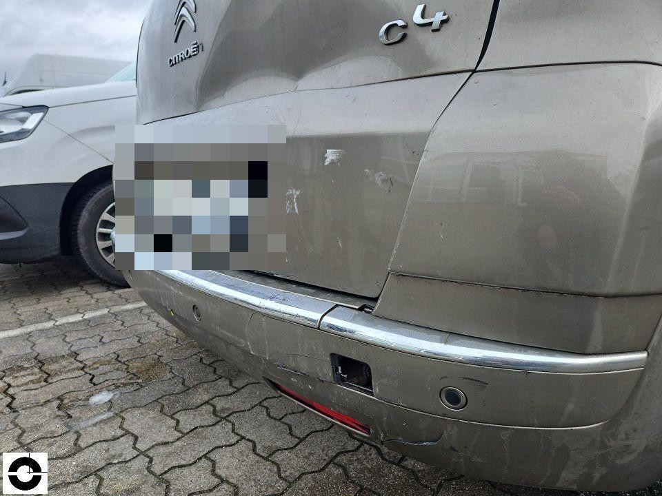 Heckansicht mit Schäden an Heckklappe und Stoßfänger, Chromleiste beschädigt