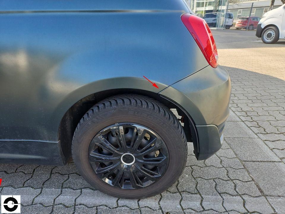 Hinterer linker Kotflügel mit Pfeil auf Schaden am Radlauf, schwarze Felge sichtbar
