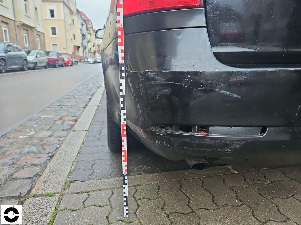 Heckansicht links, Stoßfänger mit Kratzern und Schürfspuren, Messlatte zur Dokumentation