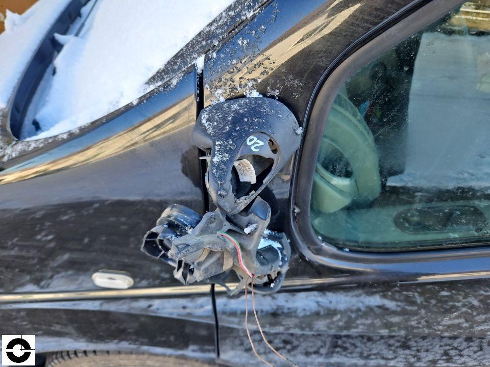 Abgerissener linker Außenspiegel mit freiliegenden Kabeln, Schnee auf Fahrzeug
